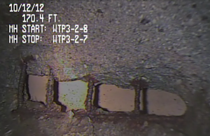Exposed reinforcing steel and void in reinforced concrete pipe