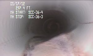 Bulge in bottom of PVC pipe, possibly due to incorrect installation on top of a rock